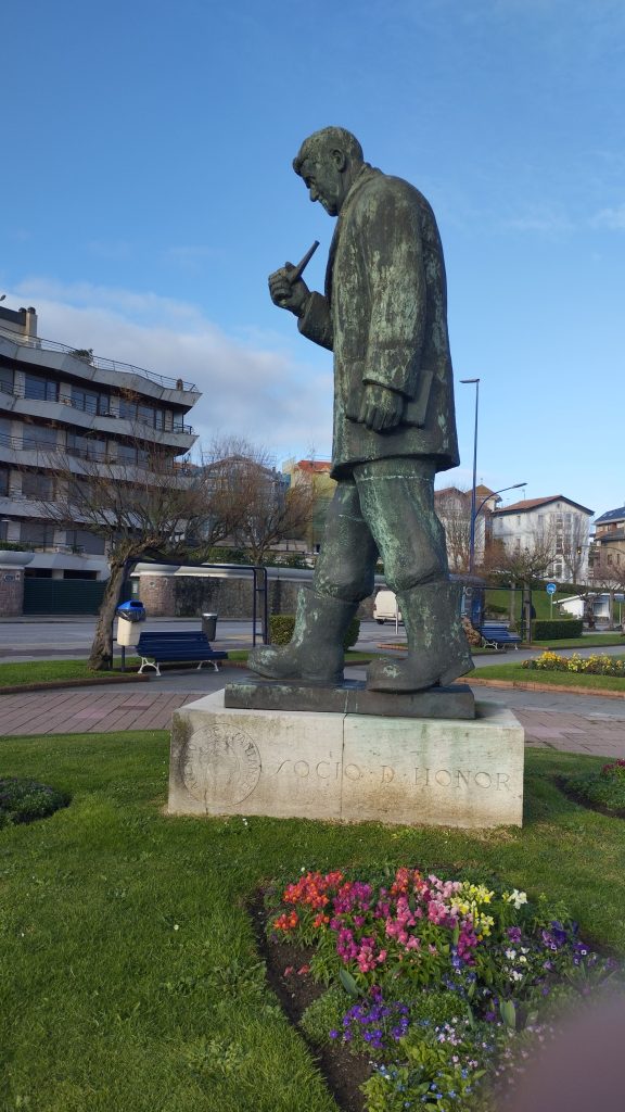 Monumento El botas Pick espaldas al mar